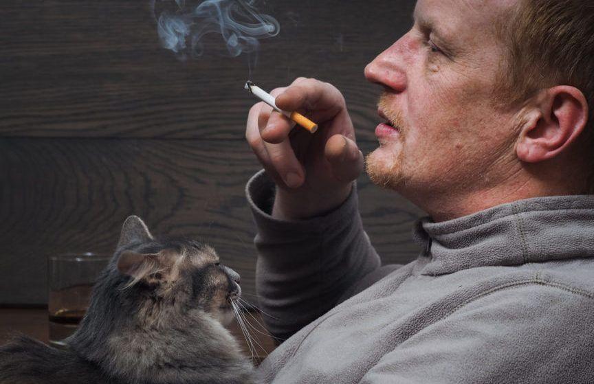 Rzuć palenie, pan z papierosem trzyma na rękach kota
