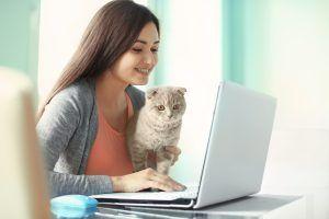 Kobieta z kotem przy komputerze